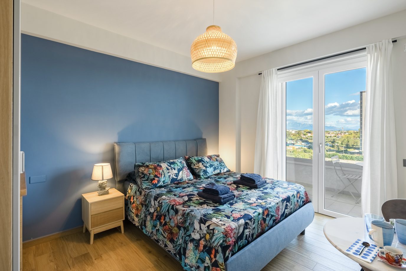Bright bedroom with a double bed and a view to the coastline