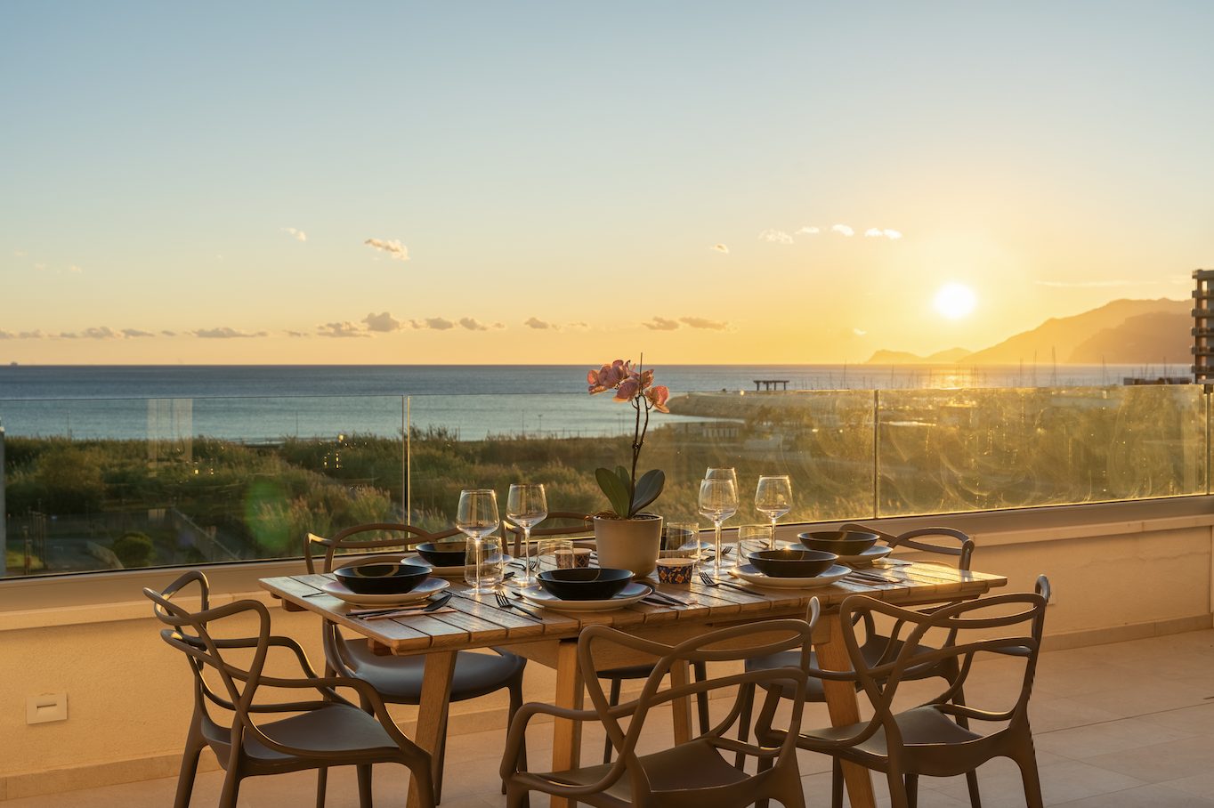 Sea-view terrace of Lantern Penthouse at sunset, with stone flooring and linen seating overlooking the Mediterranean