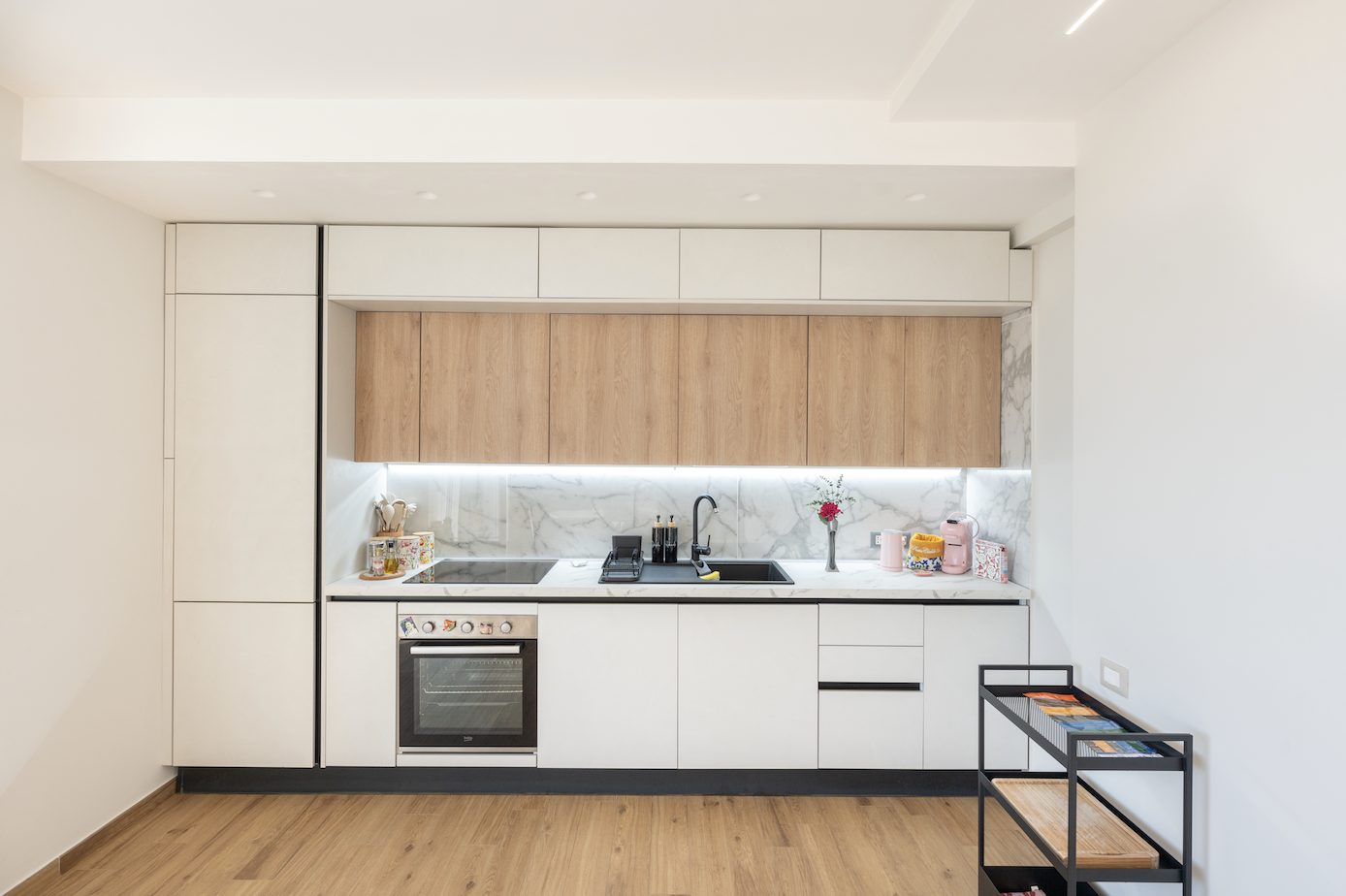 Fully equipped kitchen with light cabinetry and wooden accents