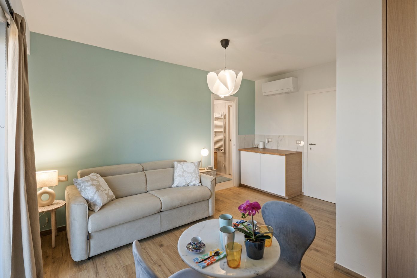 Living area with sofa, dining table and balcony doors